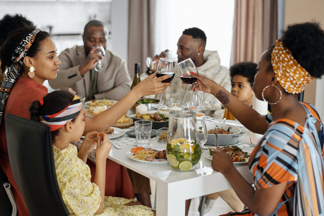 Black family sitting at dinner table drinking wine