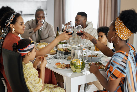 Black family sitting at dinner table drinking wine